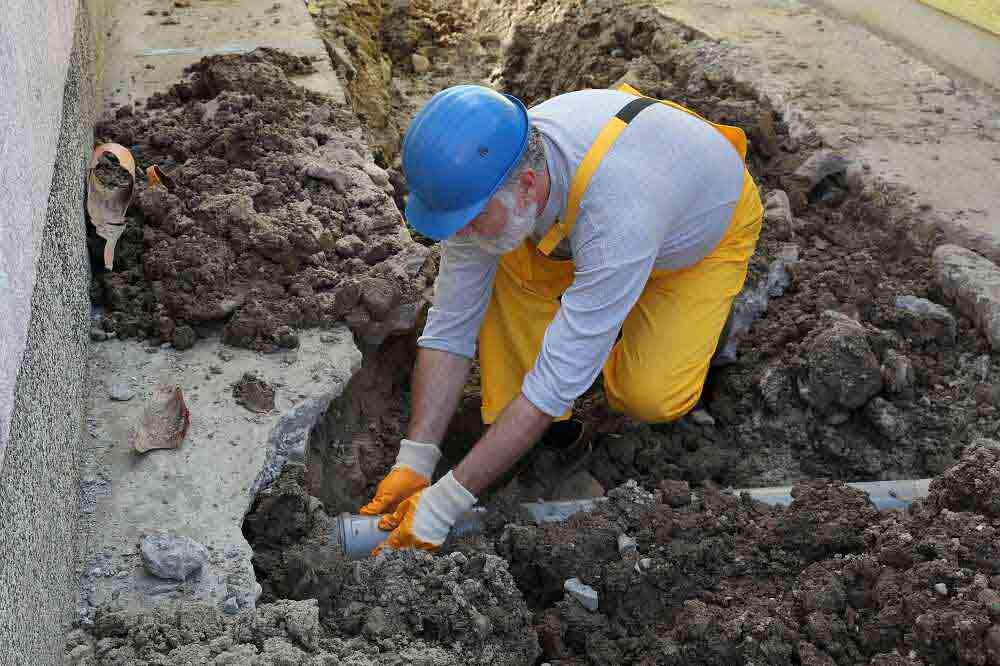 plumber fixing sewer pipe