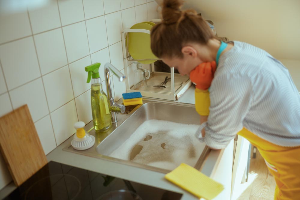 distressed person looking at overflowing sink