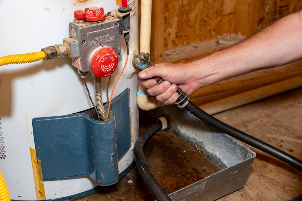 Plumber's hand connecting drain hose to water heater Change background Remove object Change lighting Describe what you want to change, e.g. “make the background white” Apply AI edit